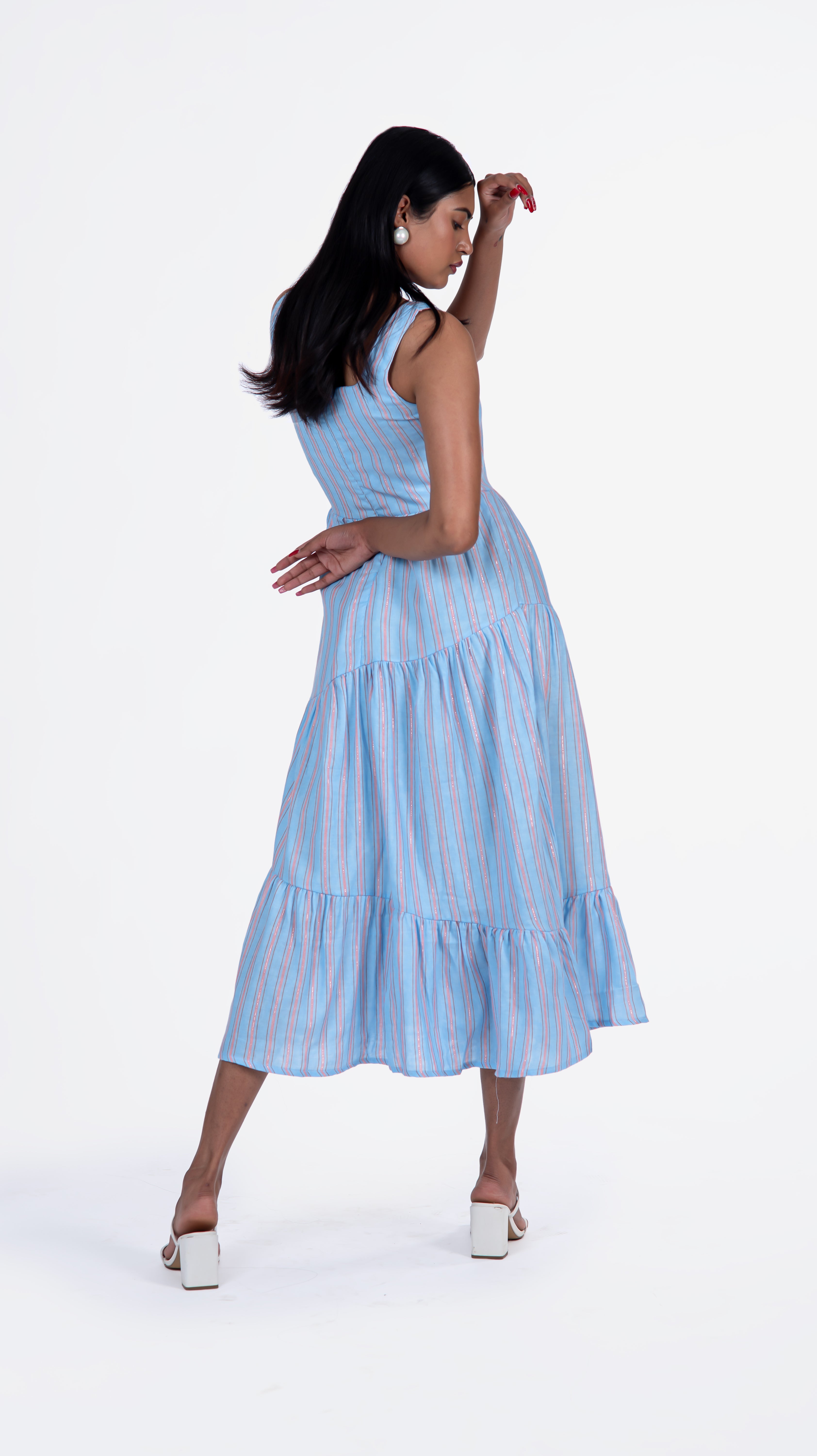 Elevate your wardrobe with Sevy's Ocean Blue Strips midi dress, designed with a sleeveless silhouette and crafted from 100% cotton. Featuring playful three layers of flares and a chic square-cut neckline, it's perfect for the modern woman. Shop now for knee-length dresses for women and printed dresses at Sevy.in!